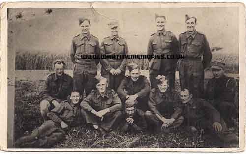 British Prisoners in a field on a farm working from Stalag XXA, Bill Carter is 3rd from right sitting down. 